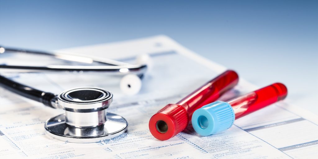 Vials of blood and stethoscope on top of lab order page.