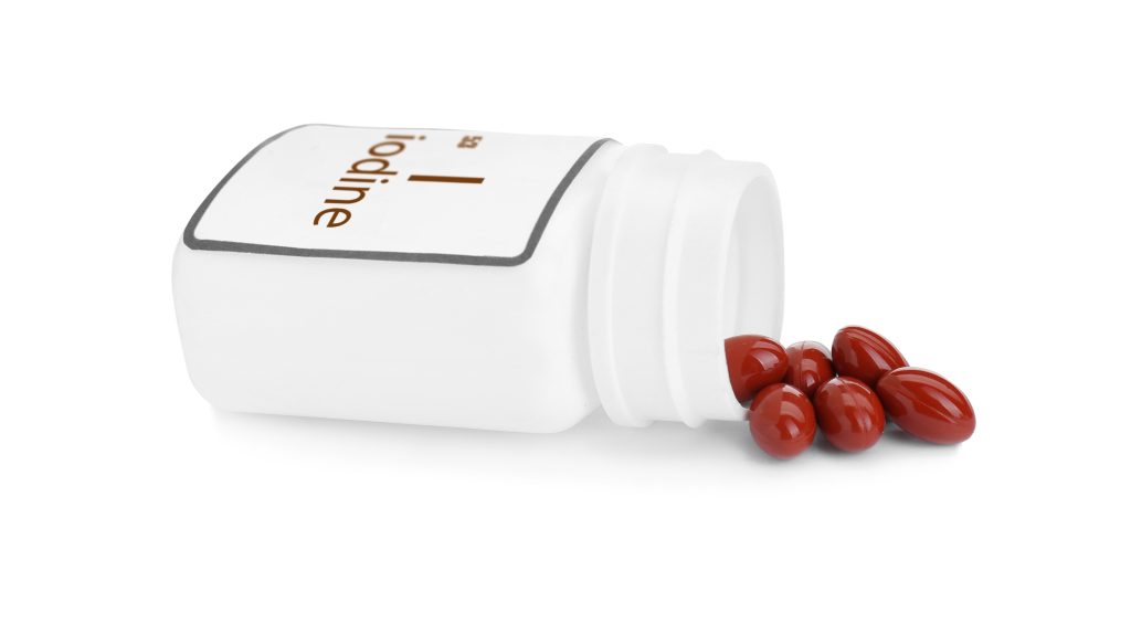 Bottle labeled Iodine on its side with pills spilling out.